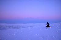 Evening snowshoe descent under arctic skies