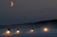 Snowmobile heading out into the wilderness at night